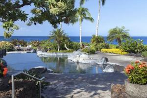 a resort with a pool with the ocean in the background at Waikoloa condo with golf & ocean views in Waikoloa
