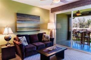 a living room with a couch and a table at Waikoloa condo with golf & ocean views in Waikoloa +12 photos