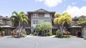 a large house with palm trees in front of it at Waikoloa condo with golf & ocean views in Waikoloa