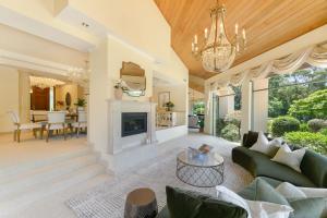 ein Wohnzimmer mit einem Kamin und einem Kronleuchter in der Unterkunft Enchanted Manor with Pool Tennis & Elegance in Cherrybrook