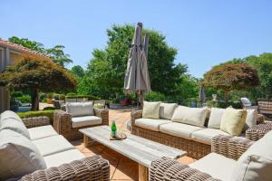 eine Terrasse mit Sofas, einem Tisch und einem Sonnenschirm in der Unterkunft Enchanted Manor with Pool Tennis & Elegance in Cherrybrook