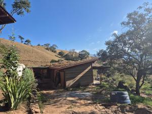 a small house with a thatched roof in a field at Casa Solar in São Bento do Sapucaí