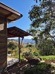 a wooden cabin with a view of a mountain at Casa Solar in São Bento do Sapucaí