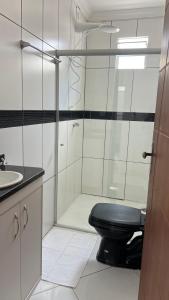 een badkamer met een zwart toilet en een wastafel bij Casa de Praia in Porto Seguro +9 foto's