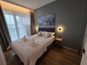 ein Schlafzimmer mit einem großen Bett mit weißen Laken und Kissen in der Unterkunft Omega Lake Family 2 in Olsztyn + 38 Fotos