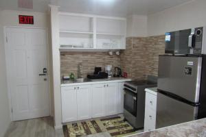 una cucina con mobili bianchi e un frigorifero in acciaio inossidabile di 103 Batts Rock Beach Condo's a Saint Michael Altre 17 foto