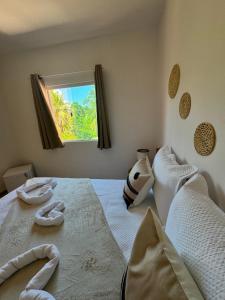 een slaapkamer met een bed met twee handdoeken erop bij Pousada Vila Mar Japaratinga in Japaratinga +58 foto's