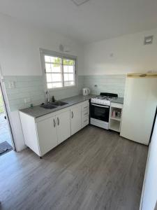 een keuken met witte kasten en een witte koelkast bij Mansilla playa in Mar del Plata