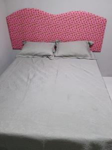 - un grand lit avec une tête de lit rose dans une chambre dans l'établissement Summer house - Alter do chão, à Santarém 16 autres photos