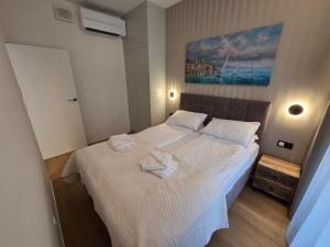 ein Schlafzimmer mit einem Bett, auf dem zwei Handtücher liegen in der Unterkunft Omega Lake Family 1 in Olsztyn + 36 Fotos