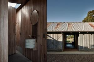 een badkamer met een spiegel op een houten muur bij Ross Farm - Dairy in Meeniyan