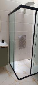 een douche met een glazen deur in een badkamer bij Matinhos balneário Riviera in Matinhos