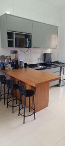 een keuken met een houten aanrecht met 4 stoelen bij Matinhos balneário Riviera in Matinhos