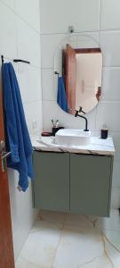 een badkamer met een wastafel en een spiegel bij Matinhos balneário Riviera in Matinhos +2 foto's