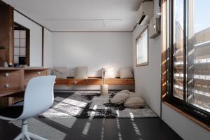 een kamer met een stoel, een tafel en een raam bij SLEEEP JP Myoko in Myoko +45 foto's