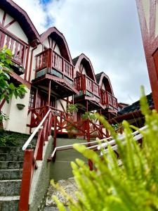a building with red balconies on the side of it at Pousada dos Esquilos in Campos do Jordão