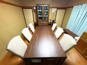 a conference room with a wooden table and white chairs at Nikko Central GOKO STAY in Nikko