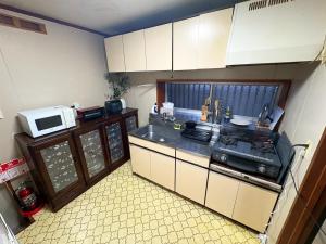 a small kitchen with a sink and a microwave at Nikko Central GOKO STAY in Nikko