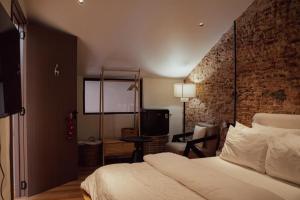 a hotel room with a bed and a tv at The Heritage 1937 in Kuching