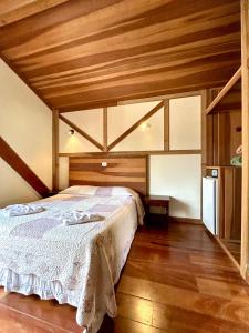 a bedroom with a bed with a wooden ceiling at Pousada dos Esquilos in Campos do Jordão