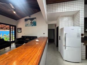 eine Küche mit einer Holztheke und einem Kühlschrank in der Unterkunft Casa Do Mar in Ubatuba