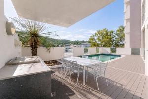 Un patio con mesa y sillas y una piscina. en Home to Holiday at Kensington in Townsville, en Townsville