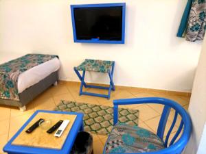 une chambre avec un lit, une table et une télévision dans l'établissement kanabesh hotel, à Charm el-Cheikh