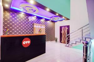 eine Lobby mit AQO-Schild an der Wand und Treppe in der Unterkunft Hotel O by OYO Gypsy and Restaurant in Khalsini