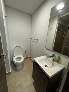 un bagno con un water, un lavandino e uno specchio di Harly's Castelo Apartment a Serena del Mar