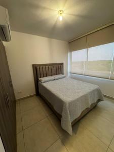 una camera da letto con un letto e una finestra di Harly's Castelo Apartment a Serena del Mar