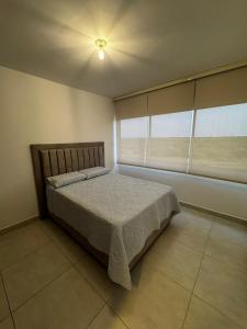 una camera da letto con un letto e una grande finestra di Harly's Castelo Apartment a Serena del Mar