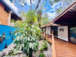 eine Holzterrasse neben einem Haus mit einer Pflanze in der Unterkunft Casa Do Mar in Ubatuba