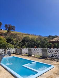 a swimming pool with a water fountain at Chalé Sophia in Camanducaia