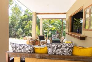 a porch with couches and chairs on a patio at Honeybird Hideaway in Crabbes Creek