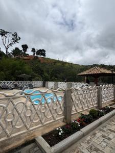 a white fence with flowers in a garden at Chalé Aconchego in Camanducaia