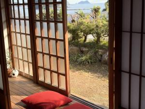 una porta aperta su un patio con vista sull'oceano di Tasogare 