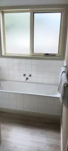 een badkamer met een bad onder een raam bij Margarets Lane in Warrnambool