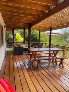 a wooden deck with a picnic table and a couch at Casa Arena y Mar in Los Órganos