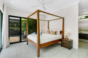 a bedroom with a canopy bed in a house at Belle Escapes Castaways in Palm Cove +69 photos