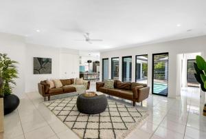 a living room with two couches and a table at Belle Escapes Castaways in Palm Cove