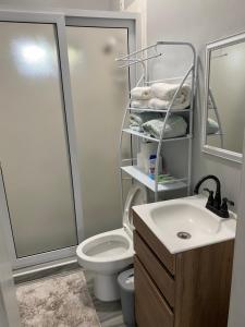 een badkamer met een toilet, een wastafel en een douche bij Beach house in Tela