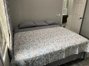 een bed in een kleine kamer met een sprei bij Beach house in Tela