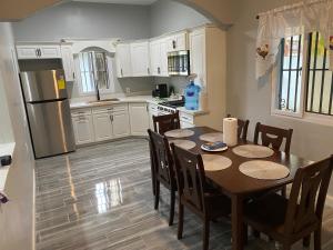 een keuken met een tafel met stoelen en een koelkast bij Beach house in Tela