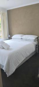 een groot wit bed met witte lakens en kussens bij Margarets Lane in Warrnambool