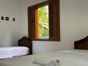 ein Zimmer mit zwei Betten und einem Fenster in der Unterkunft Casa Do Mar in Ubatuba