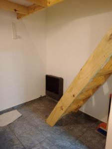 an attic room with a wooden staircase and a television at Paraje Sur in Ushuaia