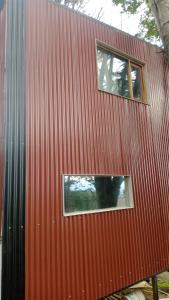 a red building with two windows on the side of it at Paraje Sur in Ushuaia +3 photos