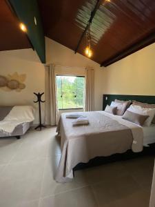 una camera da letto con un letto grande e una finestra di chalé cilla a Caparaó Velho
