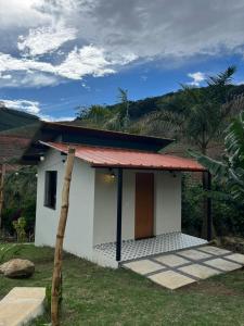 una piccola casa bianca con tetto rosso di chalé cilla a Caparaó Velho