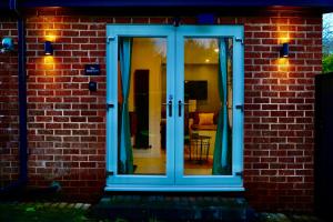a glass door with blue drapes on a brick building at The Cozy Cave in Castleton